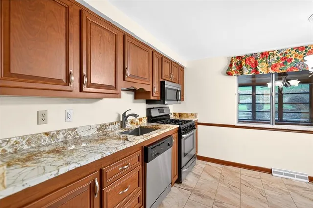 a view of a refrigerator in kitchen and an empty room with a window