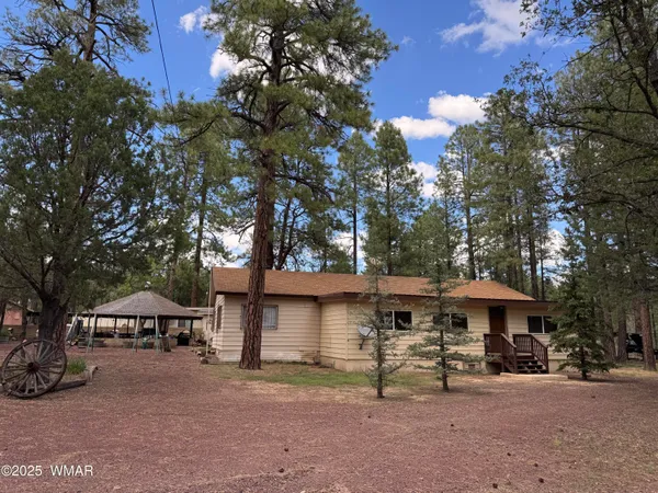 a front view of a house with a yard and trees