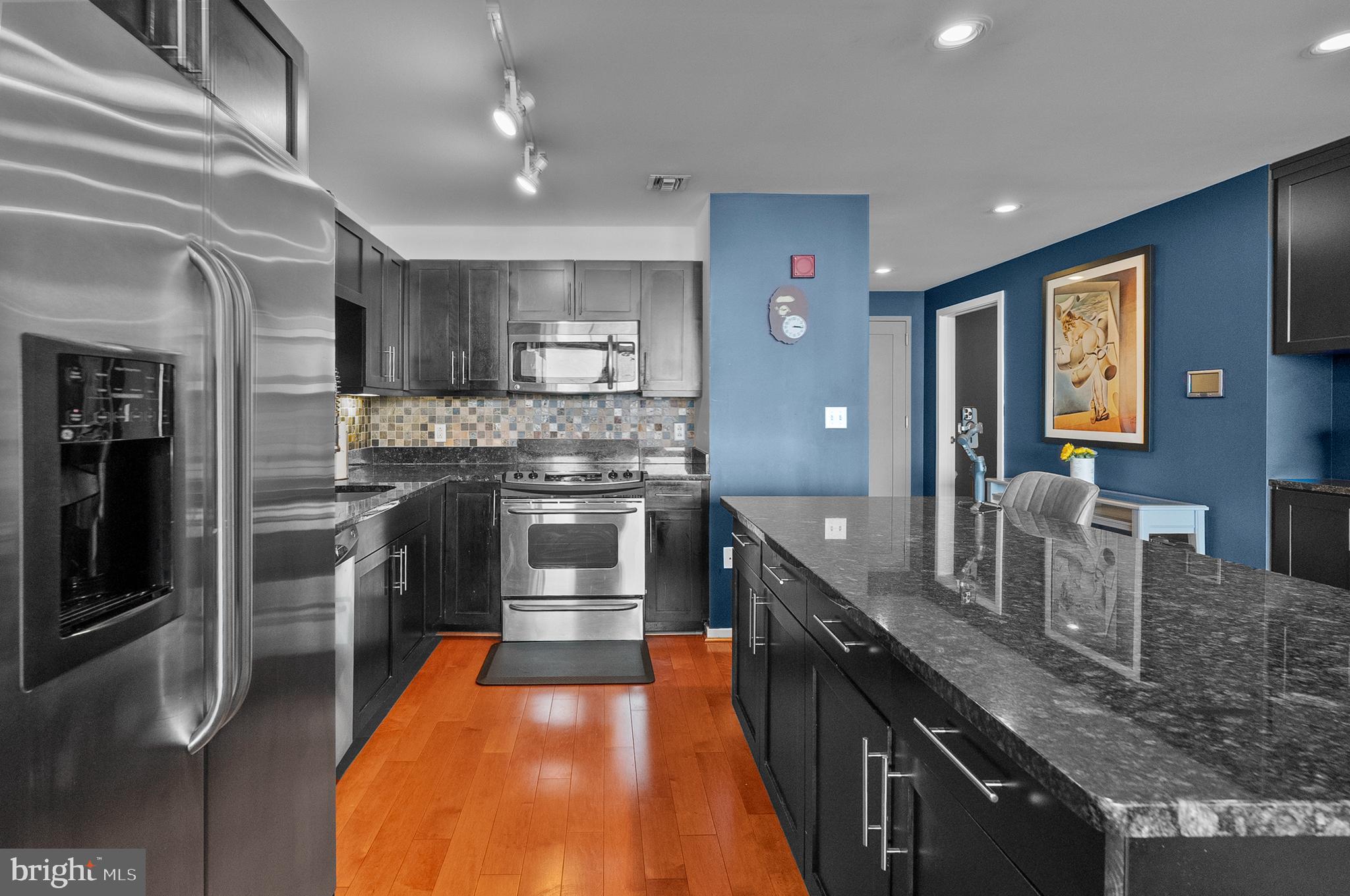 1200 Steuart Street, Unit 530 Baltimore, MD 21230 - Photo 11 of 38 a large kitchen with stainless steel appliances granite countertop a sink and a refrigerator