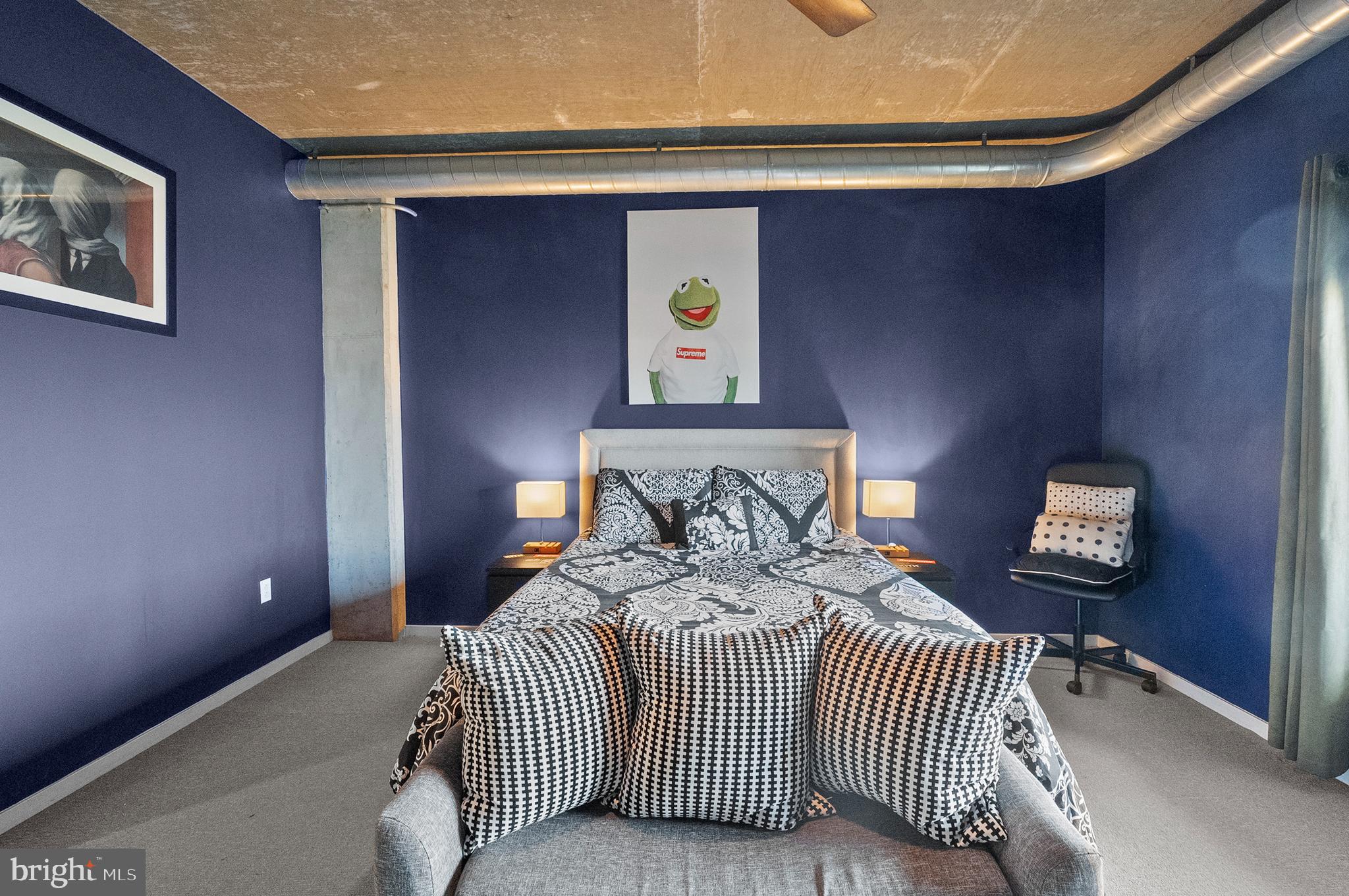 1200 Steuart Street, Unit 530 Baltimore, MD 21230 - Photo 13 of 38 a bedroom with a bed and a lamp