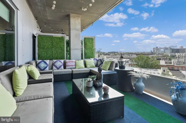 a roof deck with couches and potted plants