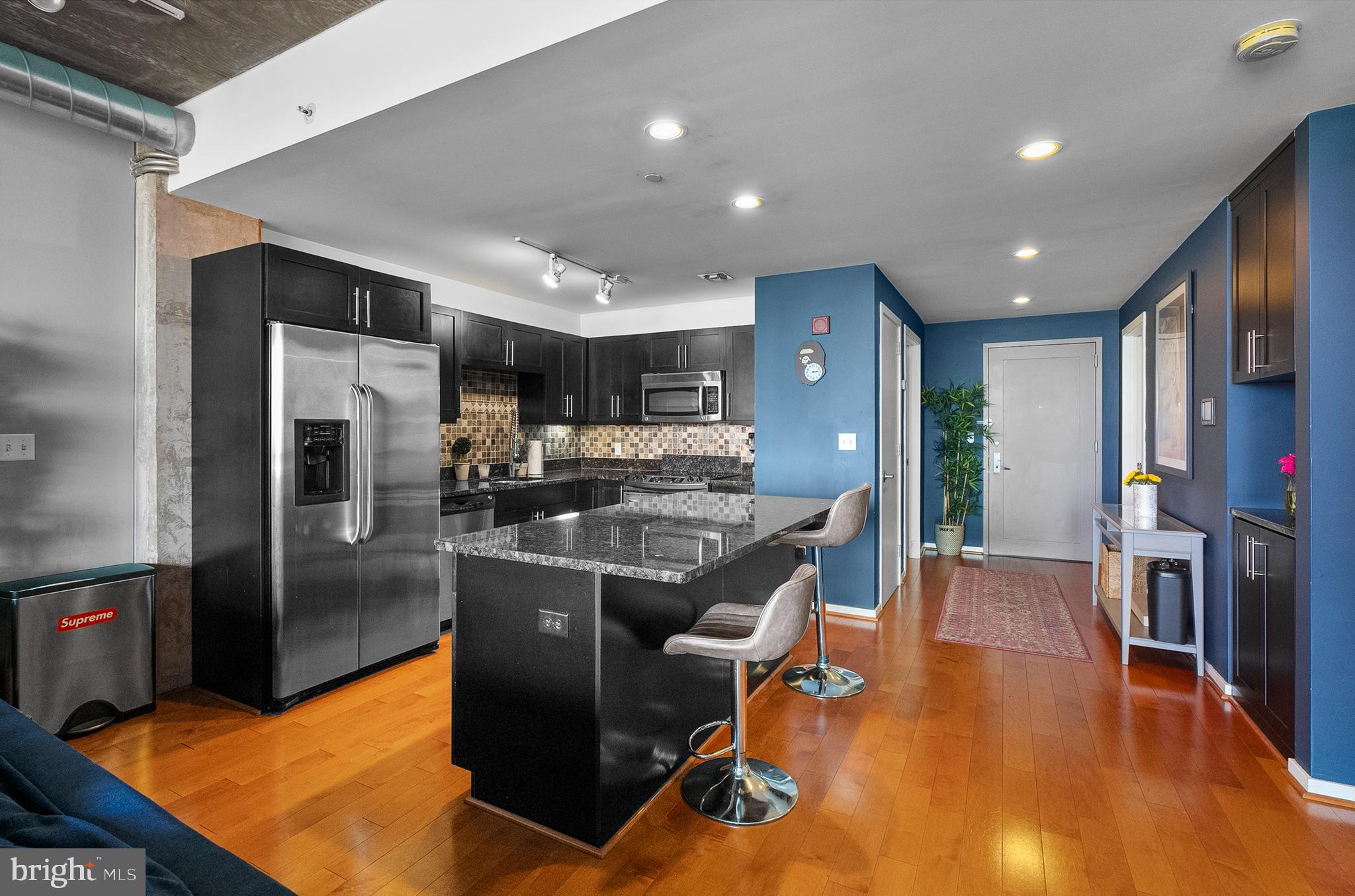 1200 Steuart Street, Unit 530 Baltimore, MD 21230 - Photo 6 of 38 a kitchen with stainless steel appliances granite countertop a refrigerator dining table and chairs
