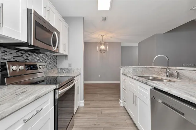 a kitchen with stainless steel appliances granite countertop a sink and a stove