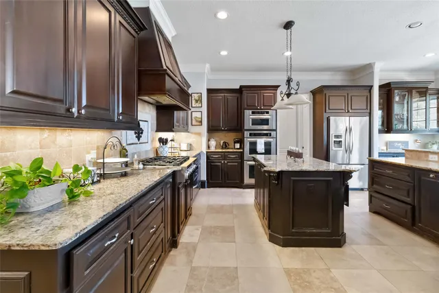 a kitchen with stainless steel appliances granite countertop a stove a sink dishwasher and a refrigerator