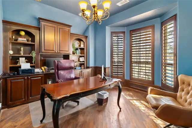 a living room with furniture two window and wooden floor