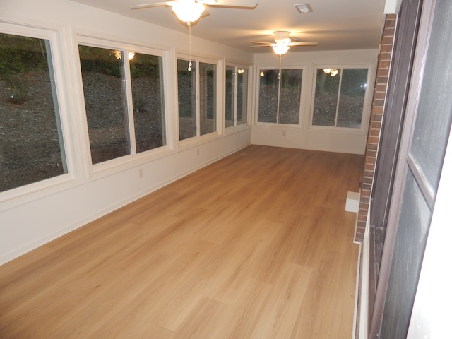 620 Downs Loop Clemson, SC 29631 - Photo 22 of 35 LVP flooring and a long wall of windows define this versatile sunroom space.