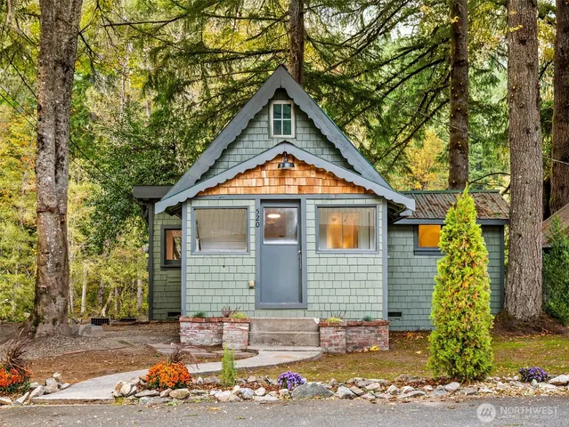 a backyard of a house with a tree table and chairs