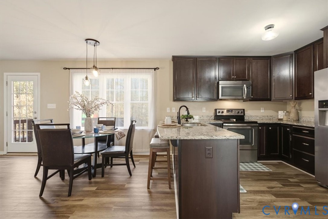 5312 Old Glory Road Chesterfield, VA 23832 - Photo 15 of 48 a kitchen with granite countertop a stove top oven a sink a dining table and chairs