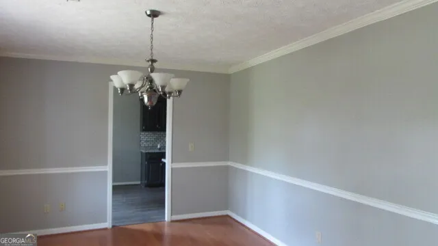 a view of a room with wooden floor and chandelier
