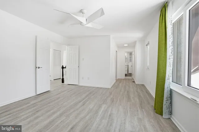 a view of a big room with wooden floor and windows