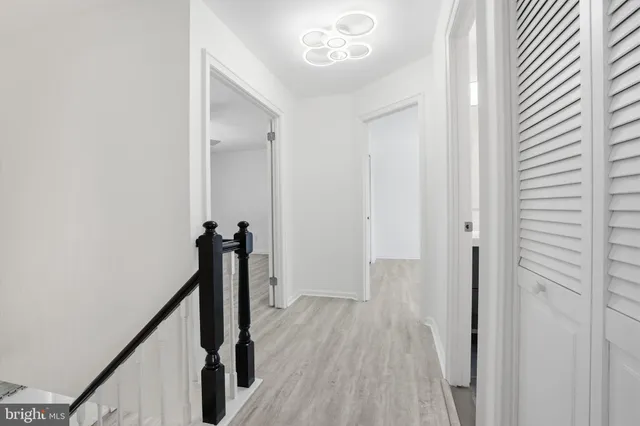 a view of a hallway with wooden floor and staircase