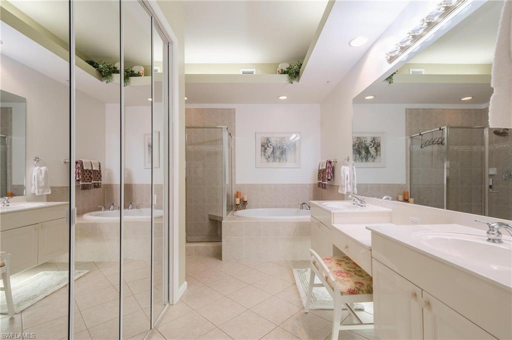 14565 Red Fox Run, Unit 613 Naples, FL 34110 - Photo 19 of 48 a bathroom with a tub a sink and mirrors