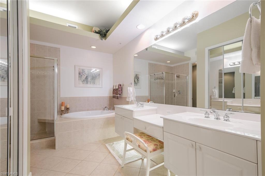 14565 Red Fox Run, Unit 613 Naples, FL 34110 - Photo 20 of 48 a spacious bathroom with a bathtub shower sink vanity and mirror