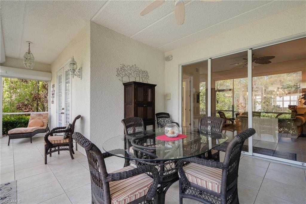 14565 Red Fox Run, Unit 613 Naples, FL 34110 - Photo 22 of 48 a living room with furniture and a floor to ceiling window