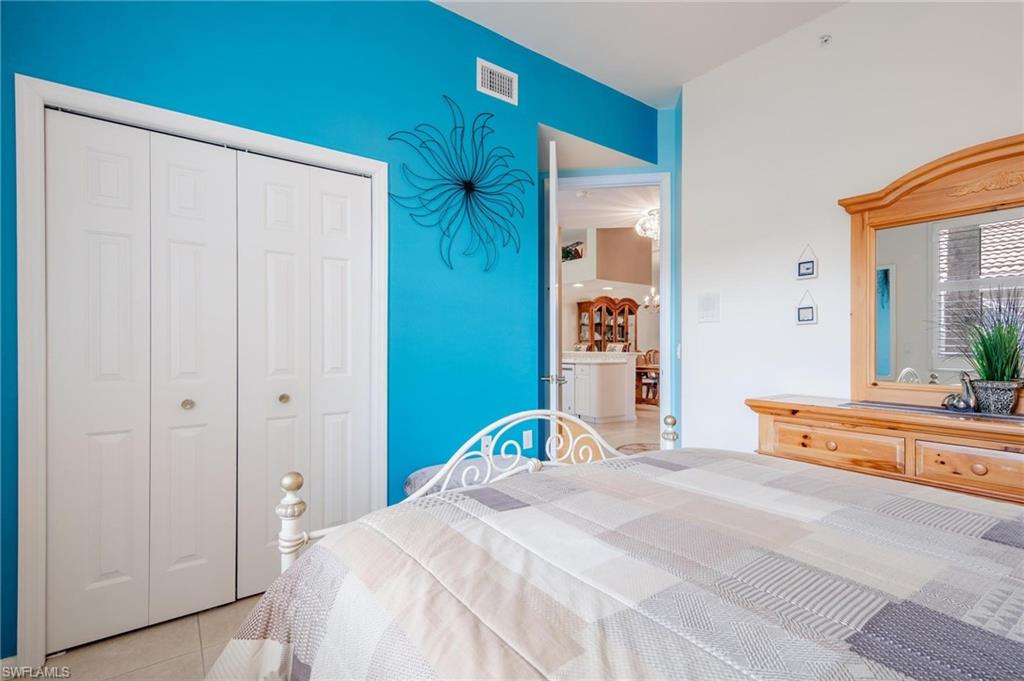 14565 Red Fox Run, Unit 613 Naples, FL 34110 - Photo 26 of 48 a bedroom with a bed and a large mirror