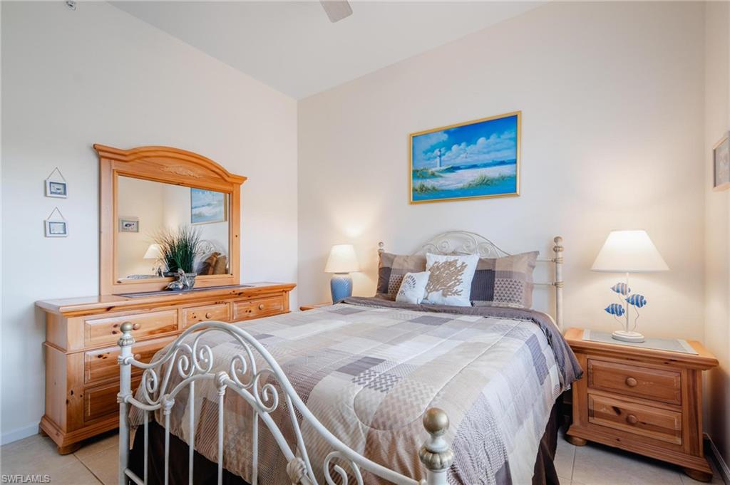 14565 Red Fox Run, Unit 613 Naples, FL 34110 - Photo 27 of 48 a bedroom with a bed and a mirror