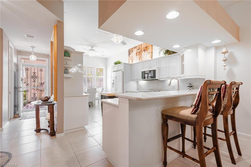 14565 Red Fox Run, Unit 613 Naples, FL 34110 - Photo 4 of 48 a kitchen with stainless steel appliances kitchen island granite countertop a refrigerator and microwave