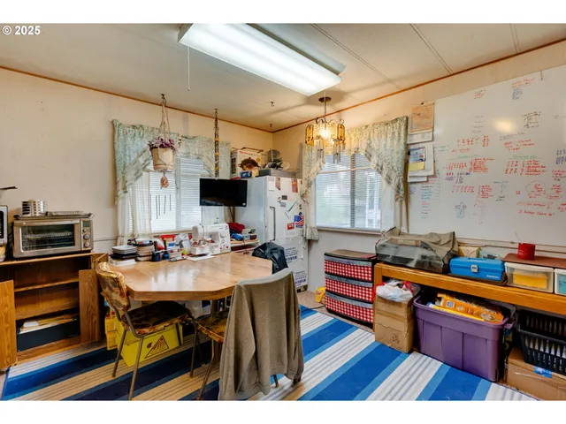 a kitchen with refrigerator and wooden floor