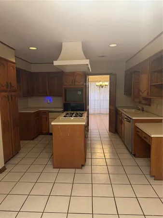 a kitchen with stainless steel appliances a sink a stove a microwave and cabinets
