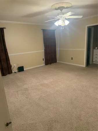 an empty room with closet and a chandelier fan