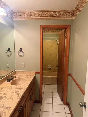 a bathroom with a granite countertop sink a mirror and shower