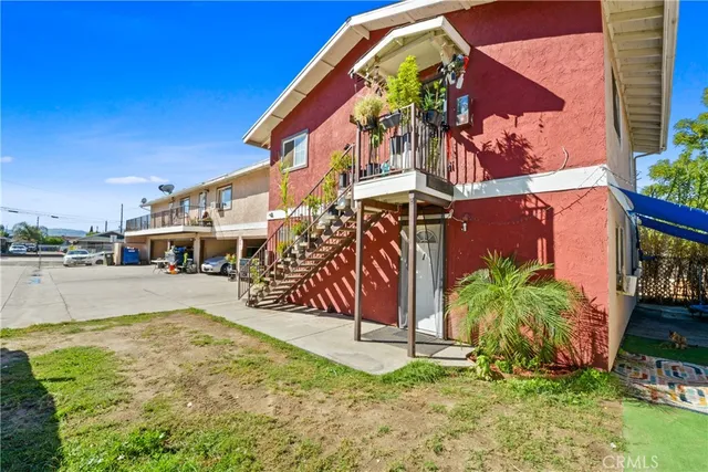 a white house with a large pool and lawn chairs
