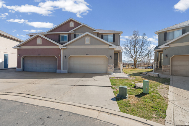 8042 North Clearwater Road West Eagle Mountain, UT 84005 - Photo 1 of 1 View of front facade with driveway, stone and stucco. Large side yard community access.