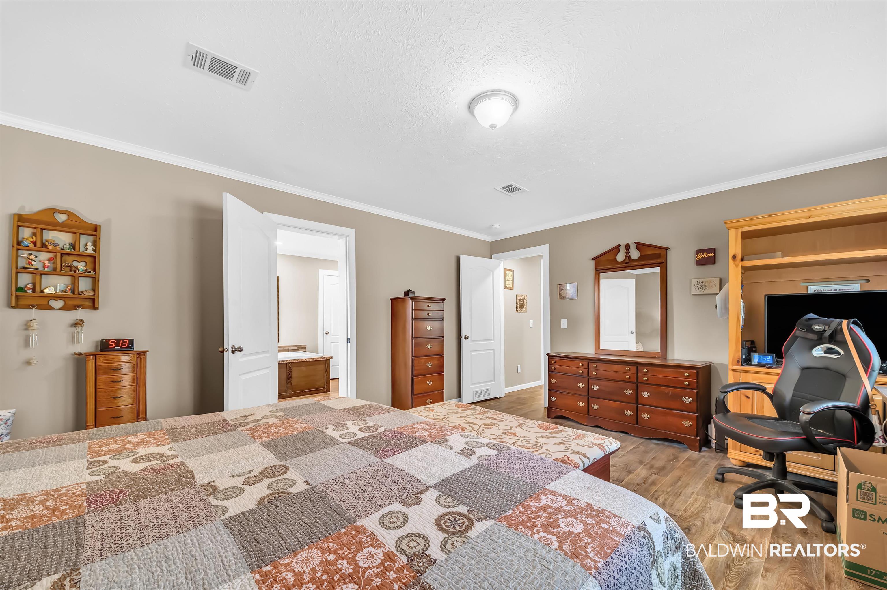 23233 Forland Road Silverhill, AL 36576 - Photo 18 of 33 Bedroom with visible vents, crown molding, and wood finished floors