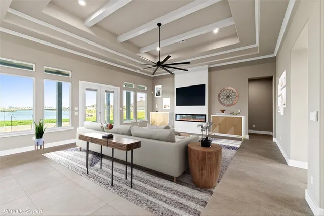 a living room with furniture and a large window with kitchen view