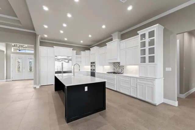 a kitchen with white cabinets and sink
