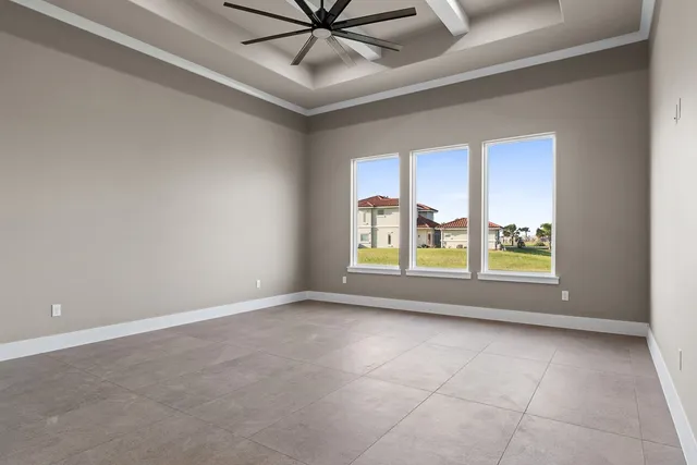 a view of an empty room with chandelier fan and fire place