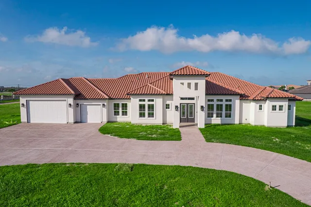 a view of house with a big yard and large trees
