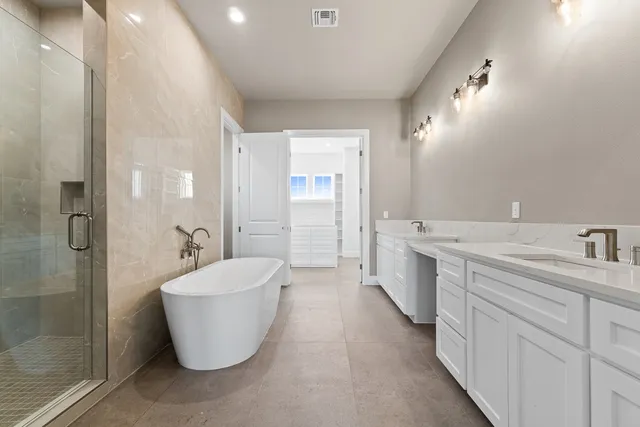 a spacious bathroom with a bathtub sink and mirror
