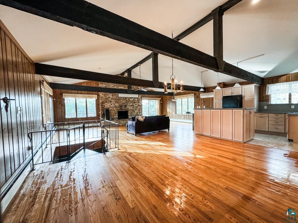 N13431 County Line Road Minong, WI 54859 - Photo 14 of 42 Unfurnished living room with a healthy amount of sunlight, a stone fireplace, and high vaulted ceiling