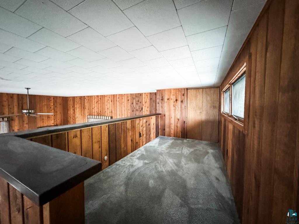 N13431 County Line Road Minong, WI 54859 - Photo 42 of 42 Bonus room with carpet floors, wood walls, and ceiling fan