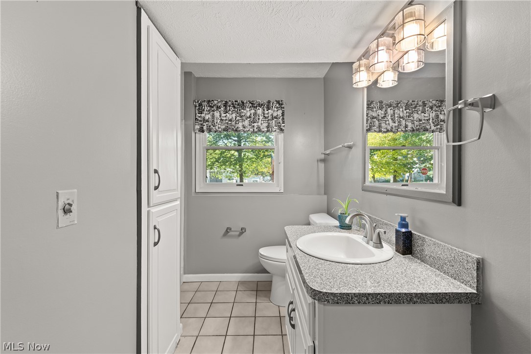 75 Houghton Road Northfield, OH 44067 - Photo 25 of 48 White vanity with a single basin sink, speckled countertop, and chrome faucet
