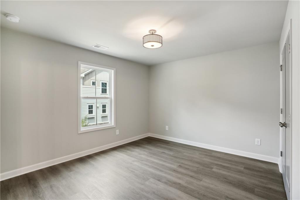 911 East Green Lane Clarkston, GA 30021 - Photo 26 of 43 an empty room with wooden floor and windows