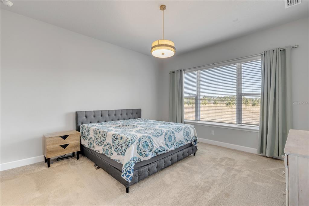 246 Azure Mist Way Daytona Beach, FL 32124 - Photo 11 of 33 a bed sitting in a bedroom next to a window