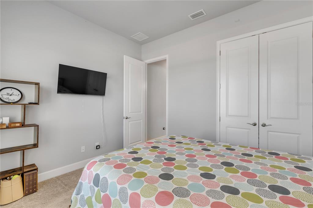 246 Azure Mist Way Daytona Beach, FL 32124 - Photo 18 of 33 a bedroom with a bed and a flat screen tv