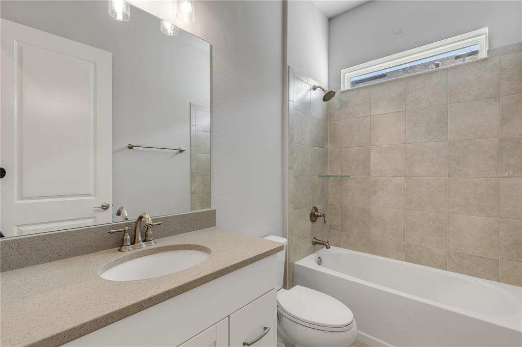 246 Azure Mist Way Daytona Beach, FL 32124 - Photo 19 of 33 a bathroom with a granite countertop bathtub shower sink vanity mirror and toilet