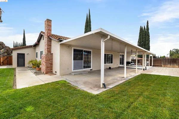 a bedroom with a bed and a lamp on dresser
