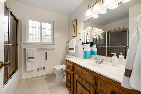 a bathroom with a sink vanity granite and toilet