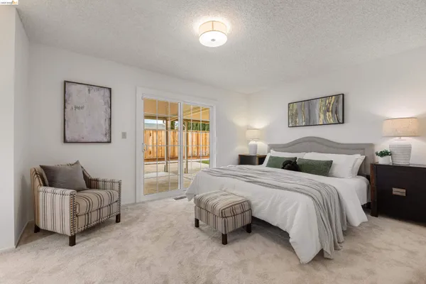a spacious bedroom with a bed and glass window