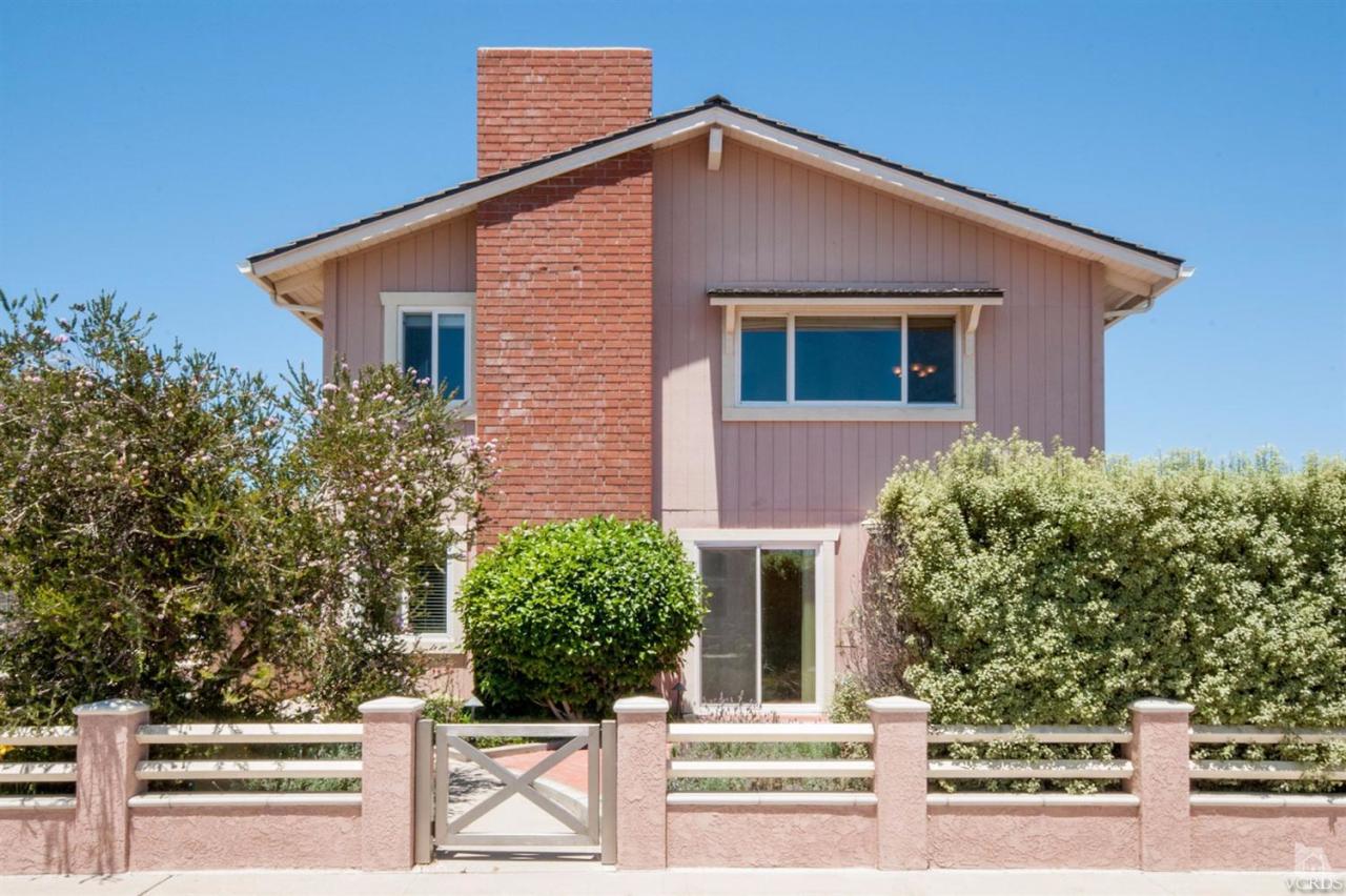 a front view of a house with plants