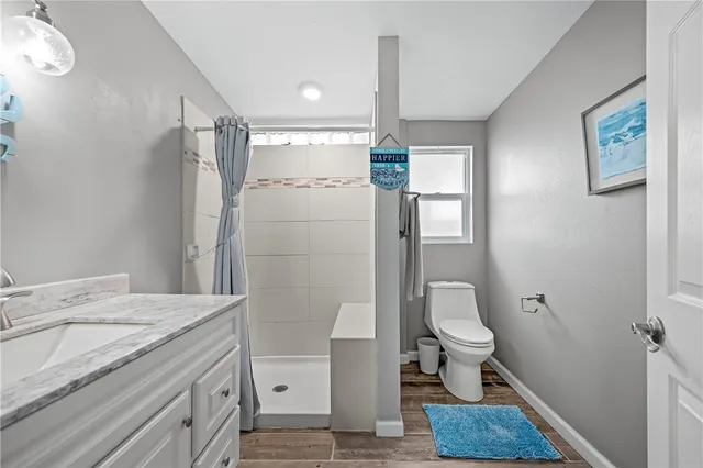 a bathroom with a granite countertop sink toilet and shower