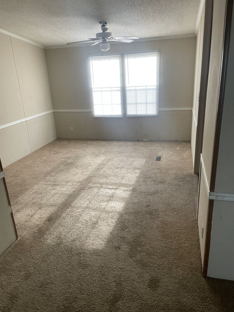 29 Cherry Lane Bourbonnais, IL 60914 - Photo 5 of 7 en empty room with windows and chandelier fan