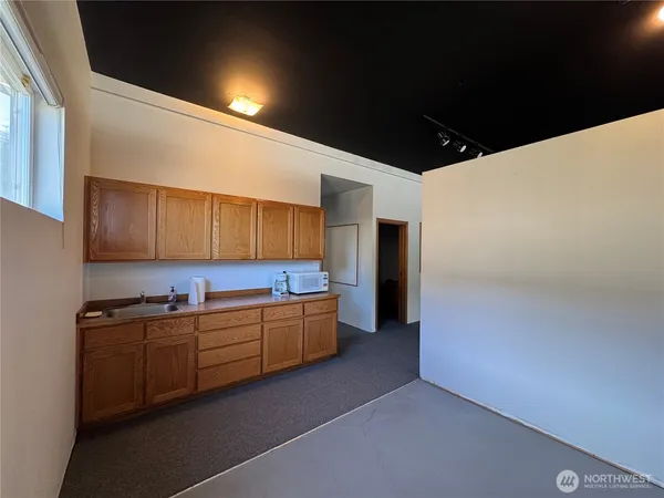 a view of an empty room with kitchen
