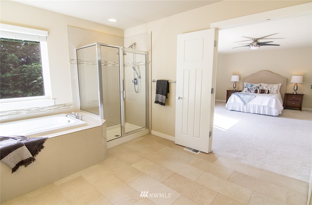 3924 185th Place Southeast Bothell, WA 98012 - Photo 18 of 25 a spacious bedroom with a bed and a chandelier