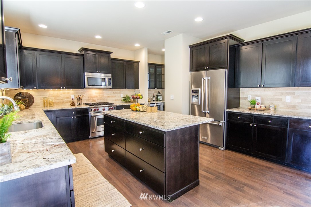 3924 185th Place Southeast Bothell, WA 98012 - Photo 8 of 25 a kitchen with stainless steel appliances granite countertop wooden cabinets a refrigerator a sink and a stove