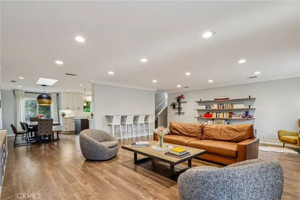 a kitchen with stainless steel appliances granite countertop a dining table chairs refrigerator sink and cabinets